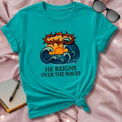 Turquoise t-shirt with a graphic design and text on a pink surface