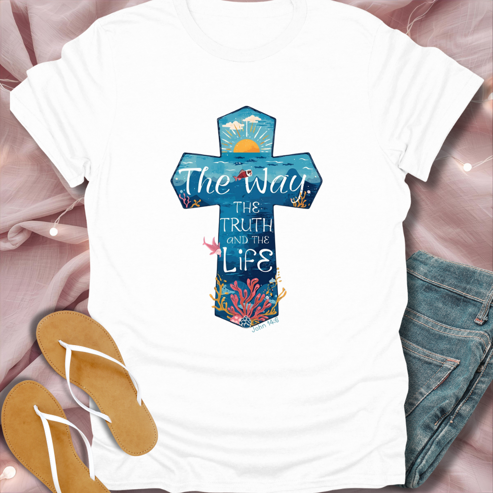 White t-shirt with a colorful cross design and text on a pink fabric background