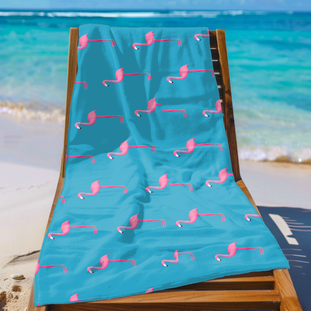 Beach towel with pink flamingo pattern on a wooden chair at the beach.