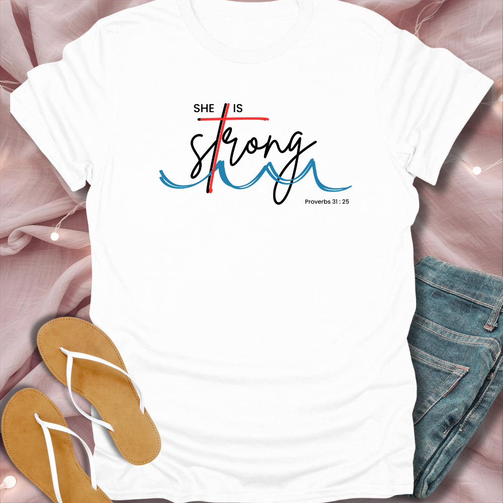 White t-shirt with 'She is Strong' text on a pink fabric background