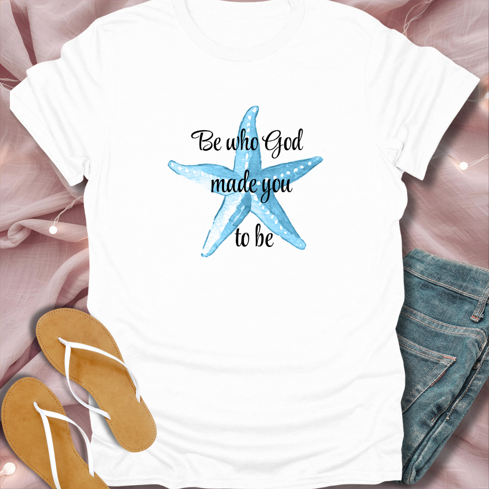 White t-shirt with a blue starfish and text on a pink fabric background