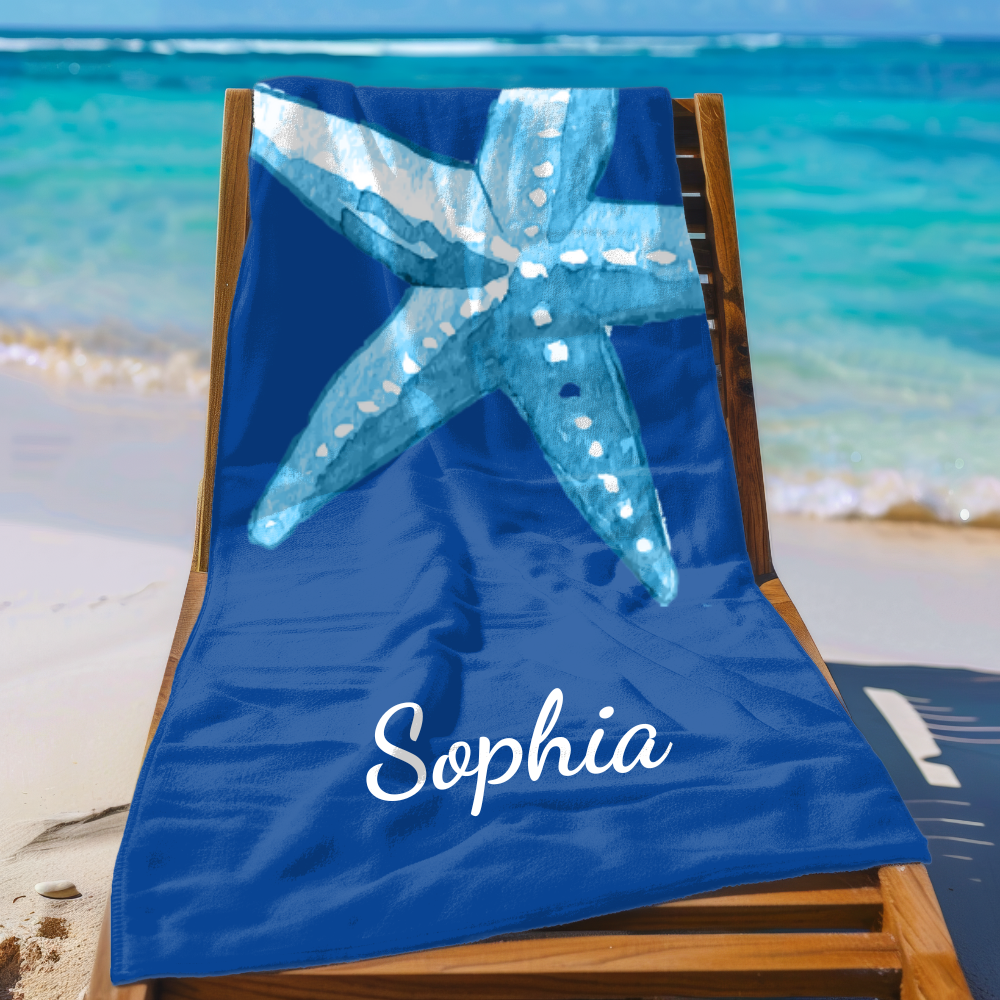 Blue beach towel with starfish design and 'Sophia' text on a wooden chair at the beach.