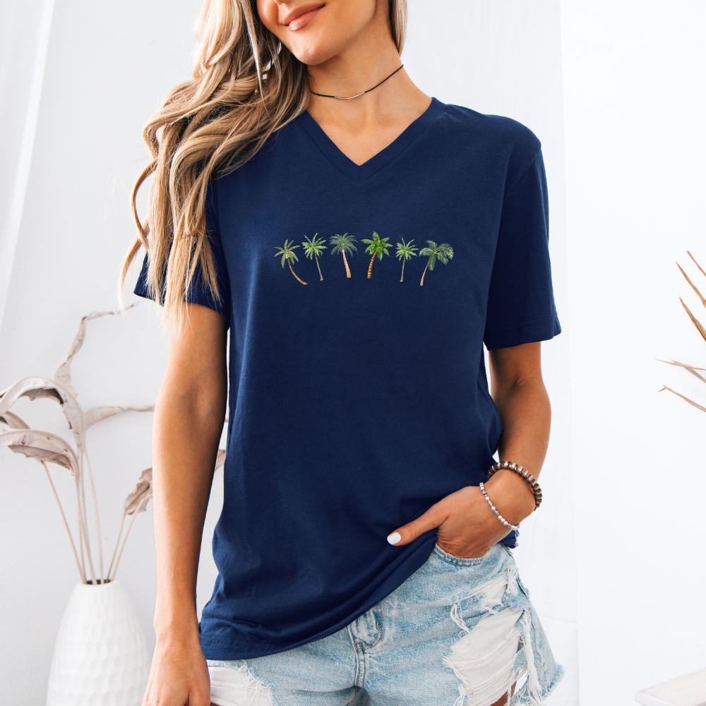 Woman wearing a navy blue t-shirt with palm tree design against a white background