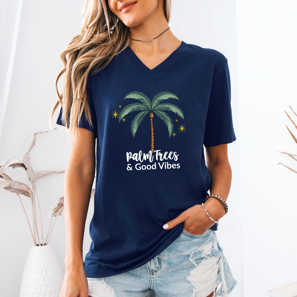 Woman wearing a navy blue t-shirt with palm tree design and text.