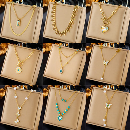 Assorted gold necklaces featuring hearts, butterflies, pearls, and gemstone pendants