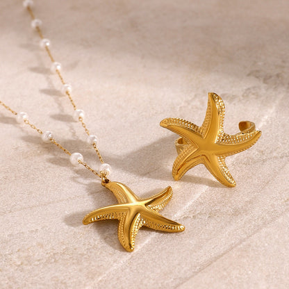 Close-up of starfish-shaped gold ring on textured display