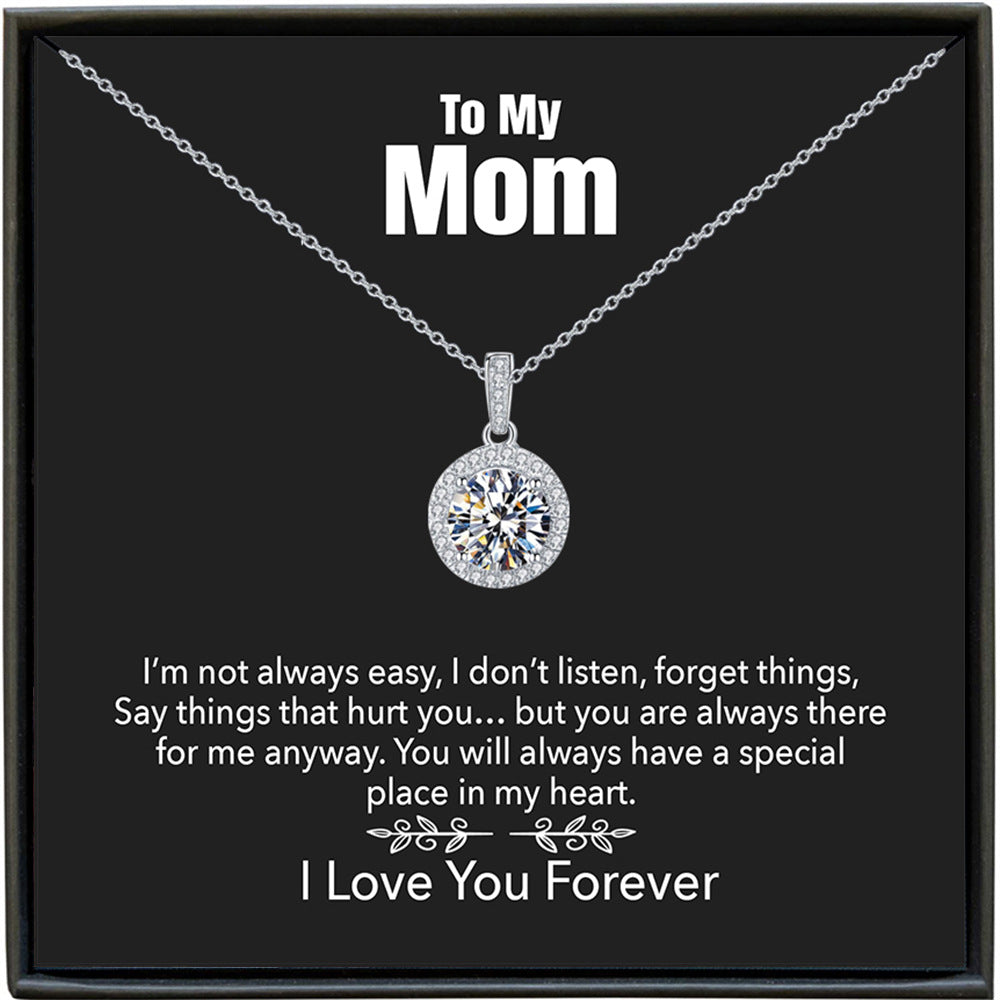 Silver necklace with a diamond pendant on a black card for mom, featuring a message.