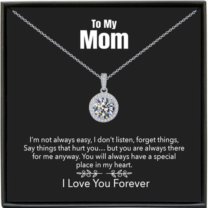 Silver necklace with a diamond pendant on a black card for mom, featuring a message.