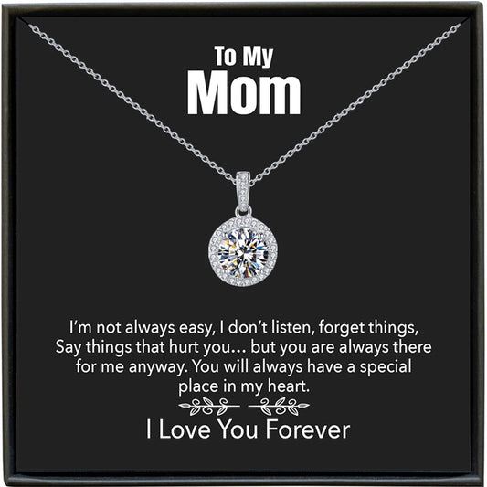 Silver necklace with a diamond pendant on a black card for mom, featuring a message.