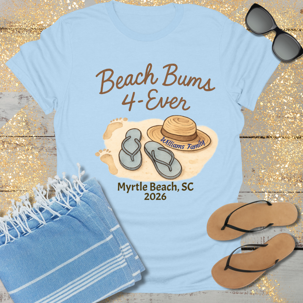 Light blue t-shirt with 'Beach Bums 4-Ever' design, sunglasses, towel, and flip-flops on a wooden surface.