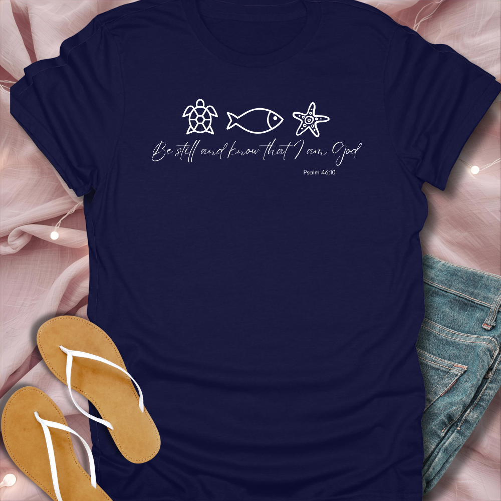 Navy blue t-shirt with white graphics and text on a pink fabric background