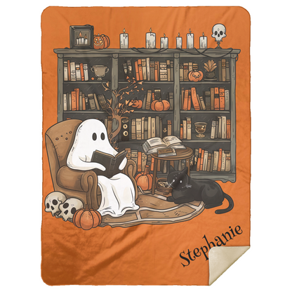 Blanket with ghost reading a book and cat in front of a bookshelf on an orange background
