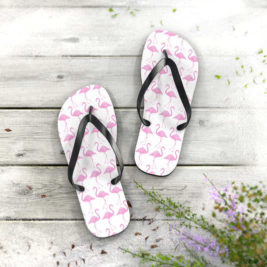 Pair of flip-flops with colorful pattern on a wooden surface with flowers.