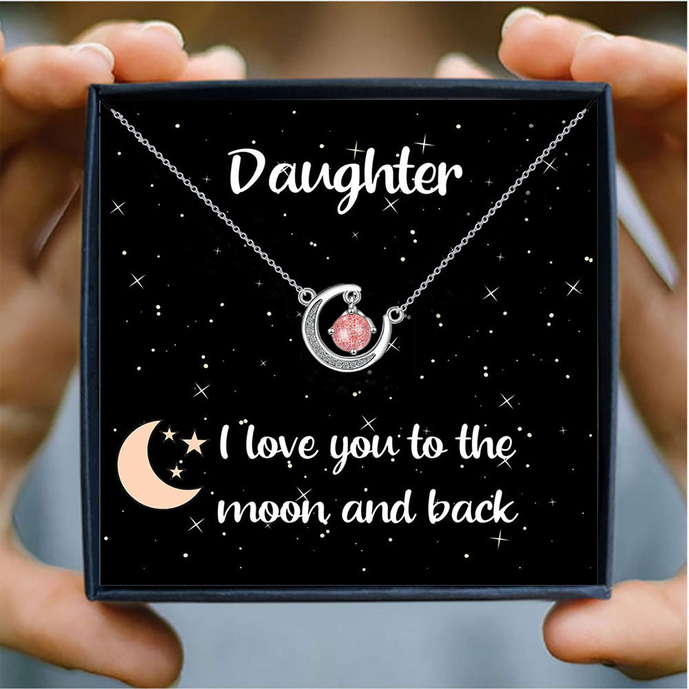 Daughter gift necklace with crescent moon and pink crystal, presented in a starry gift box with the message “I love you to the moon and back.”