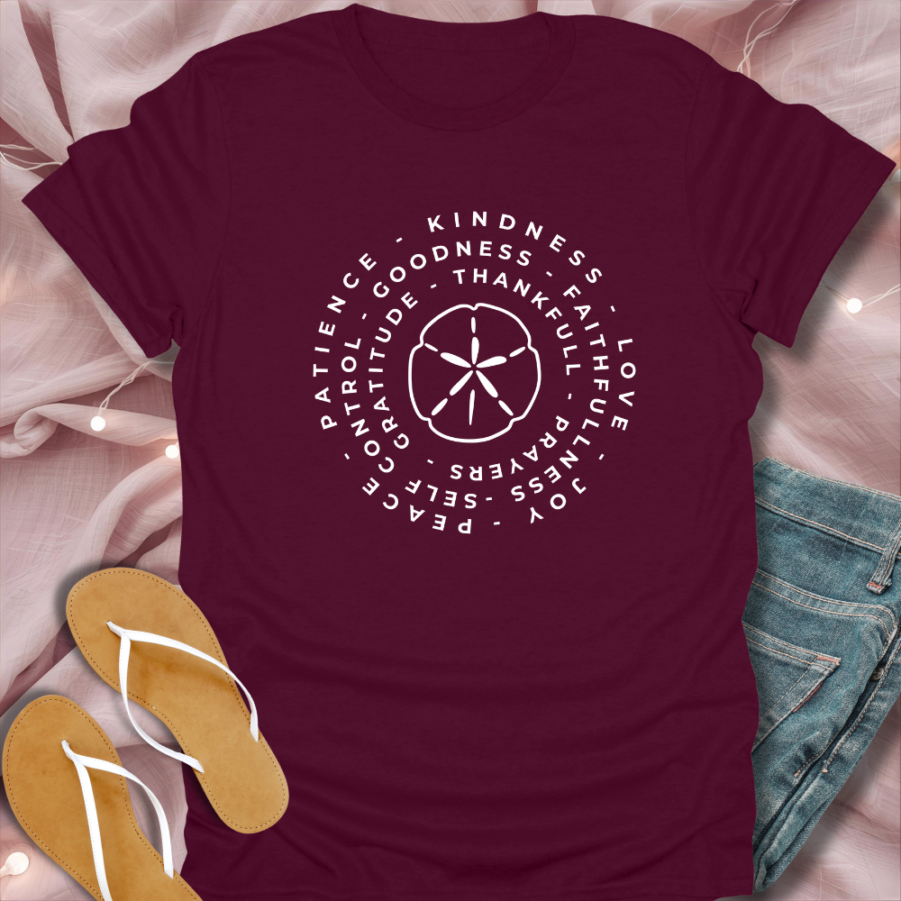 Maroon t-shirt with motivational text design on a light pink fabric background