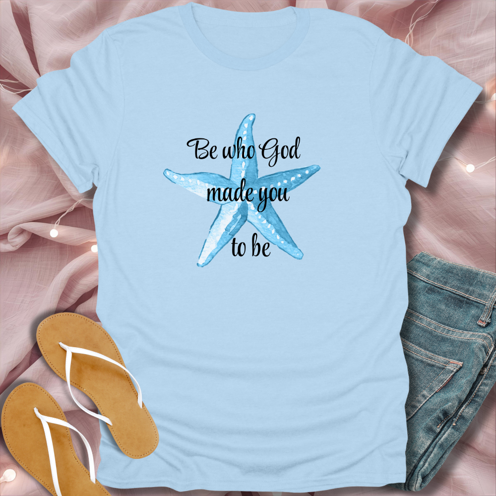 Light blue t-shirt with starfish design and text on a pink fabric background
