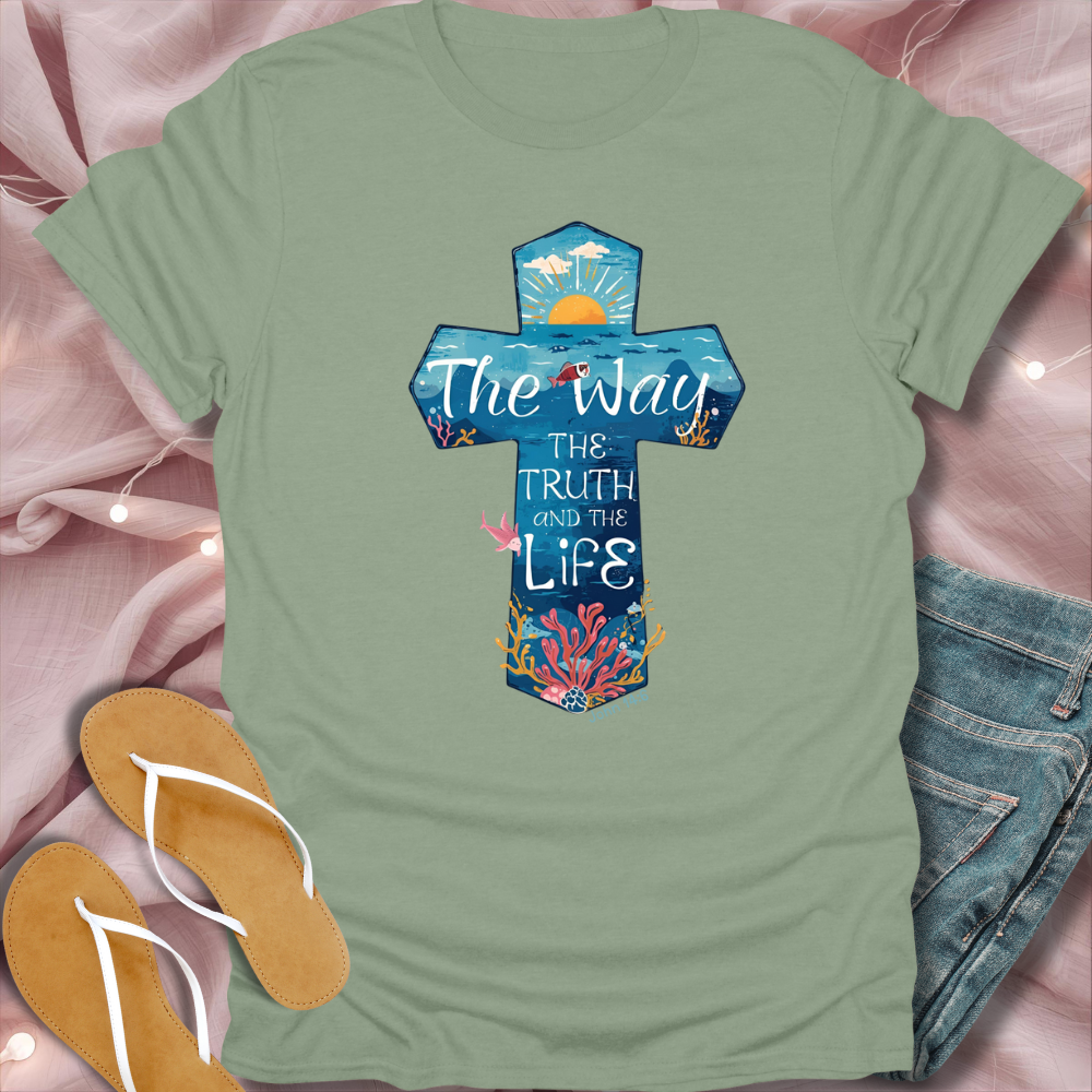 Green t-shirt with a cross design and text on a pink fabric background