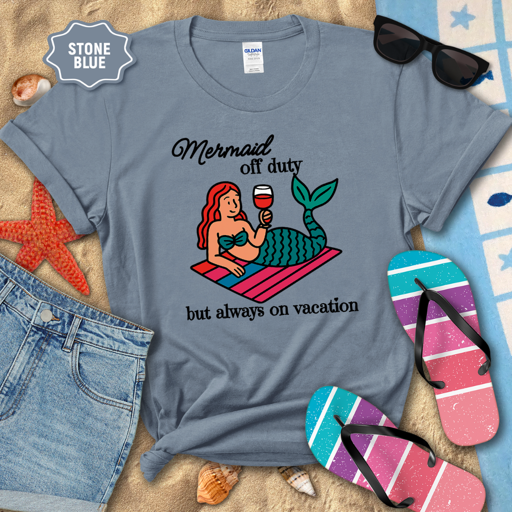 Stone blue t-shirt with mermaid graphic and text on a beach-themed background