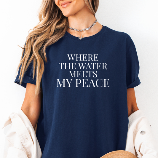 Navy blue t-shirt with 'WHERE THE WATER MEETS MY PEACE' text worn by a person.