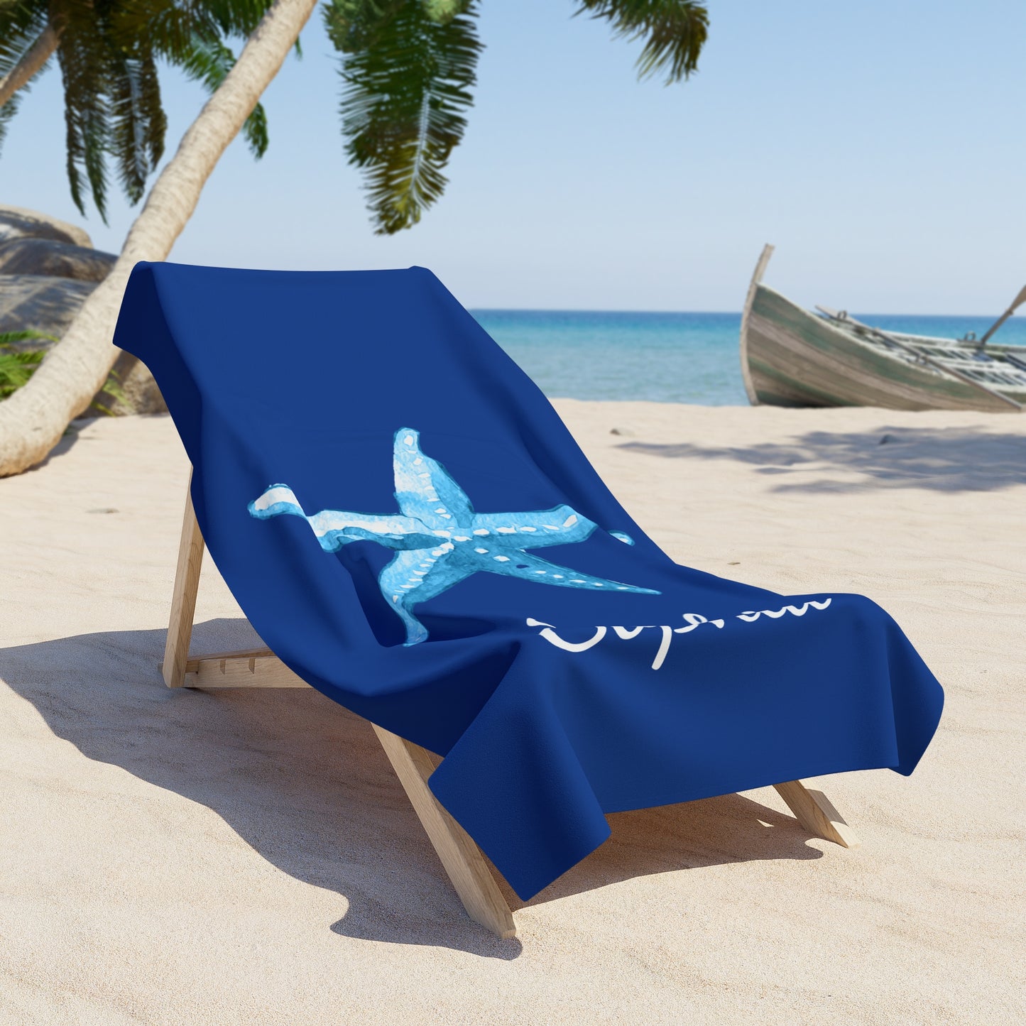 Blue beach towel with a starfish design on a lounge chair at a beach.
