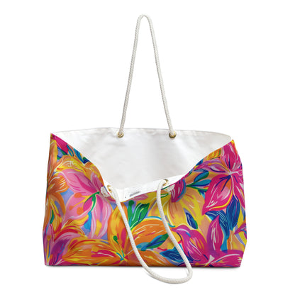 Oversized Beach bag with bright tropical lily floral print in pink, orange, and yellow tones held open to display white liner.