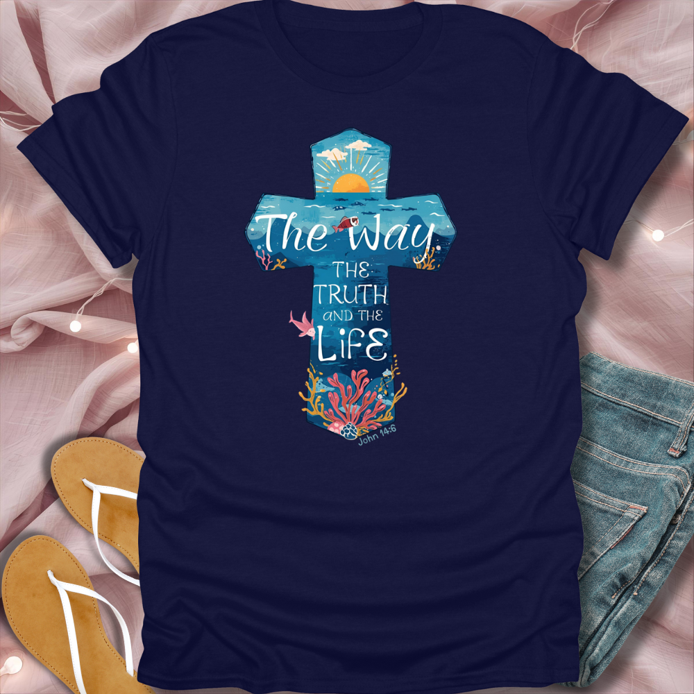 Navy blue t-shirt with a cross design and text on a pink fabric background