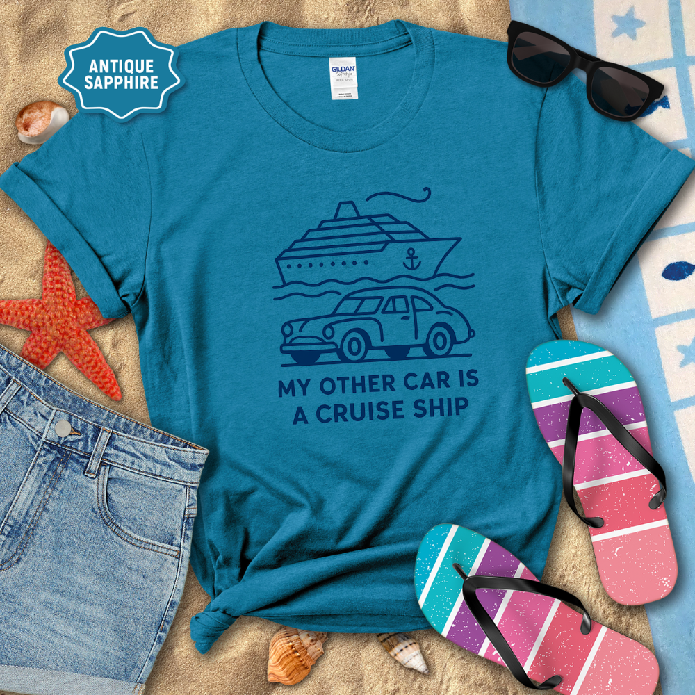 Blue t-shirt with a cruise ship graphic and text, surrounded by beach accessories.