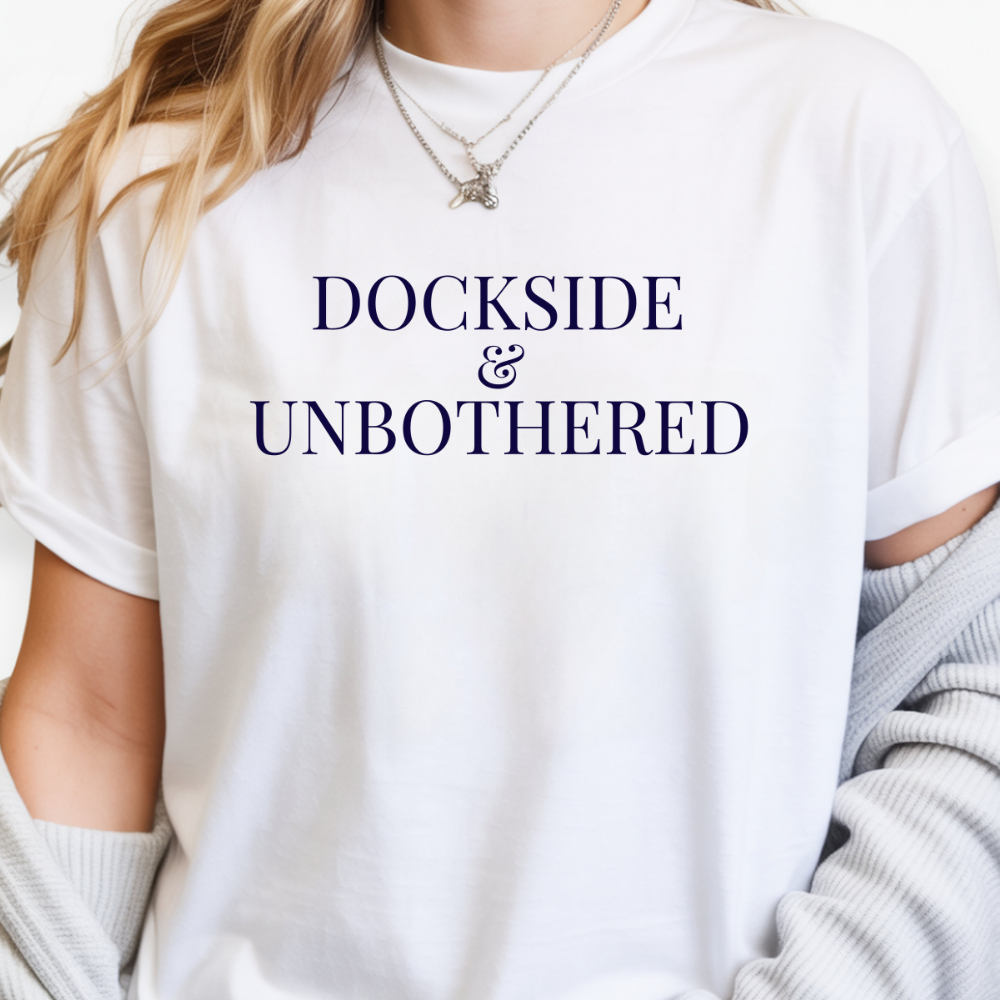 White t-shirt with 'DOCKSIDE & UNBOtherED' text worn by a person.