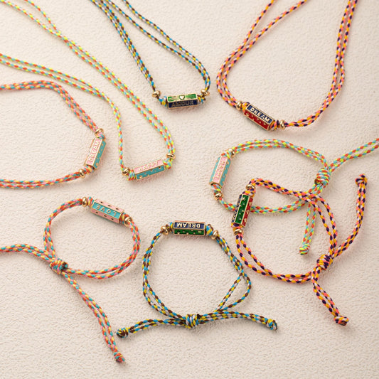Colorful braided bracelets with metal clasps on a light background