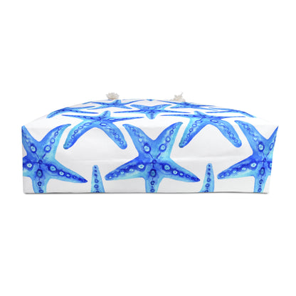 Bottom side of oversized beach tote with bold blue starfish pattern on white background