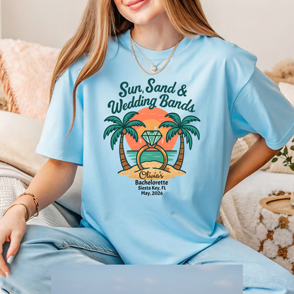 Person wearing a light blue t-shirt with a tropical design and text.