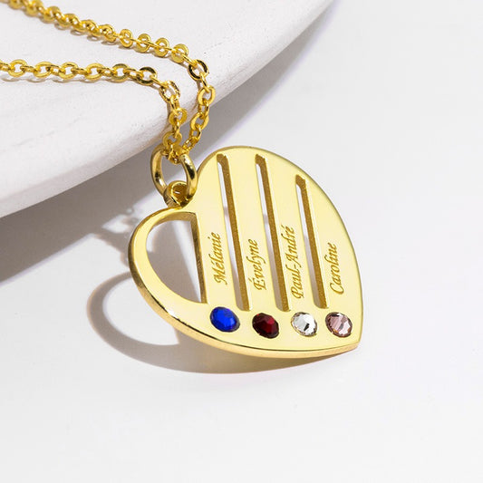 Gold heart-shaped necklace with engraved names and colored stones on a white background