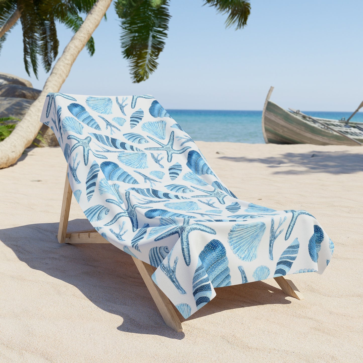 Beach chair with a blue and white patterned towel on a sandy beach with palm trees and ocean in the background.