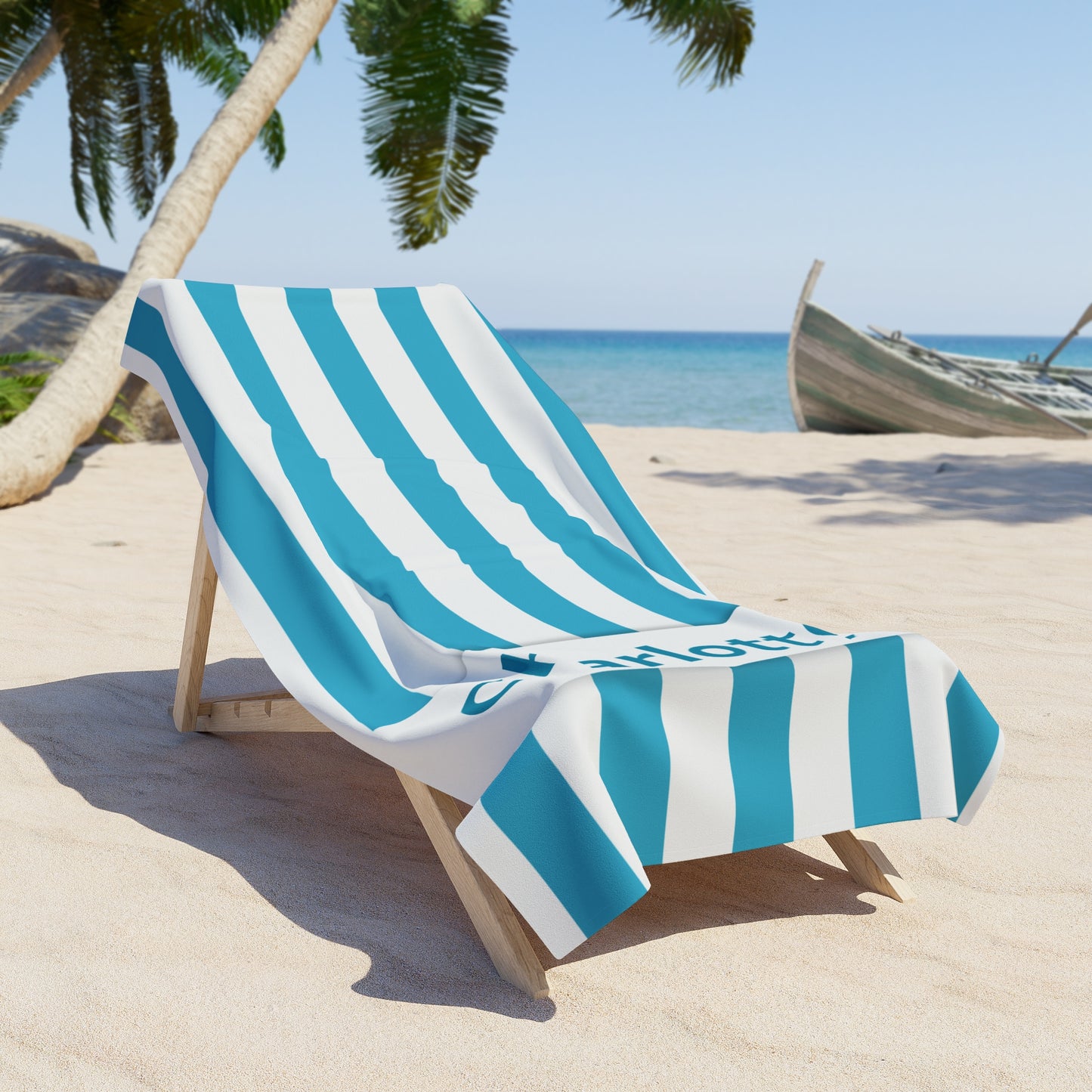 Beach chair with blue and white striped towel on a sandy beach with palm trees and ocean in the background.