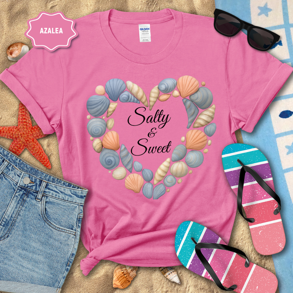 Pink t-shirt with seashell design and 'Salty & Sweet' text, surrounded by beach accessories.
