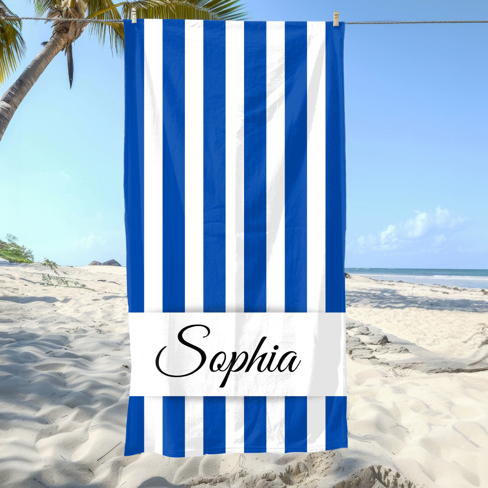 Blue and white striped towel with 'Sophia' on a beach