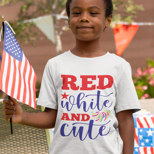 Young child wearing a “Red, White and Cute” patriotic T-shirt, holding an American flag and smiling at a 4th of July celebration.