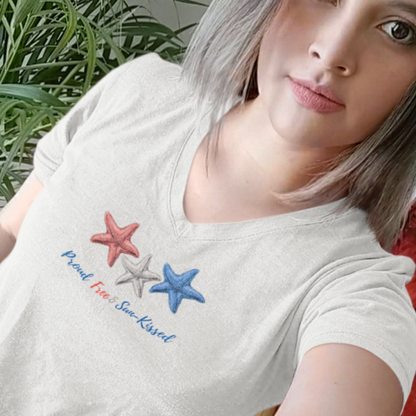 Selfie of a girl wearing a Light gray V-neck T-shirt with red, white, and blue starfish and the phrase "Proud, Free & Sun-Kissed" printed on the front.