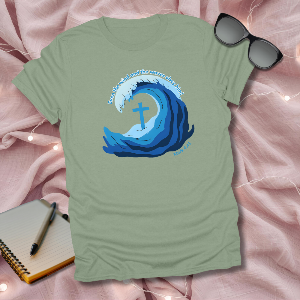 Green t-shirt with blue wave design featuring a cross on a pink fabric background