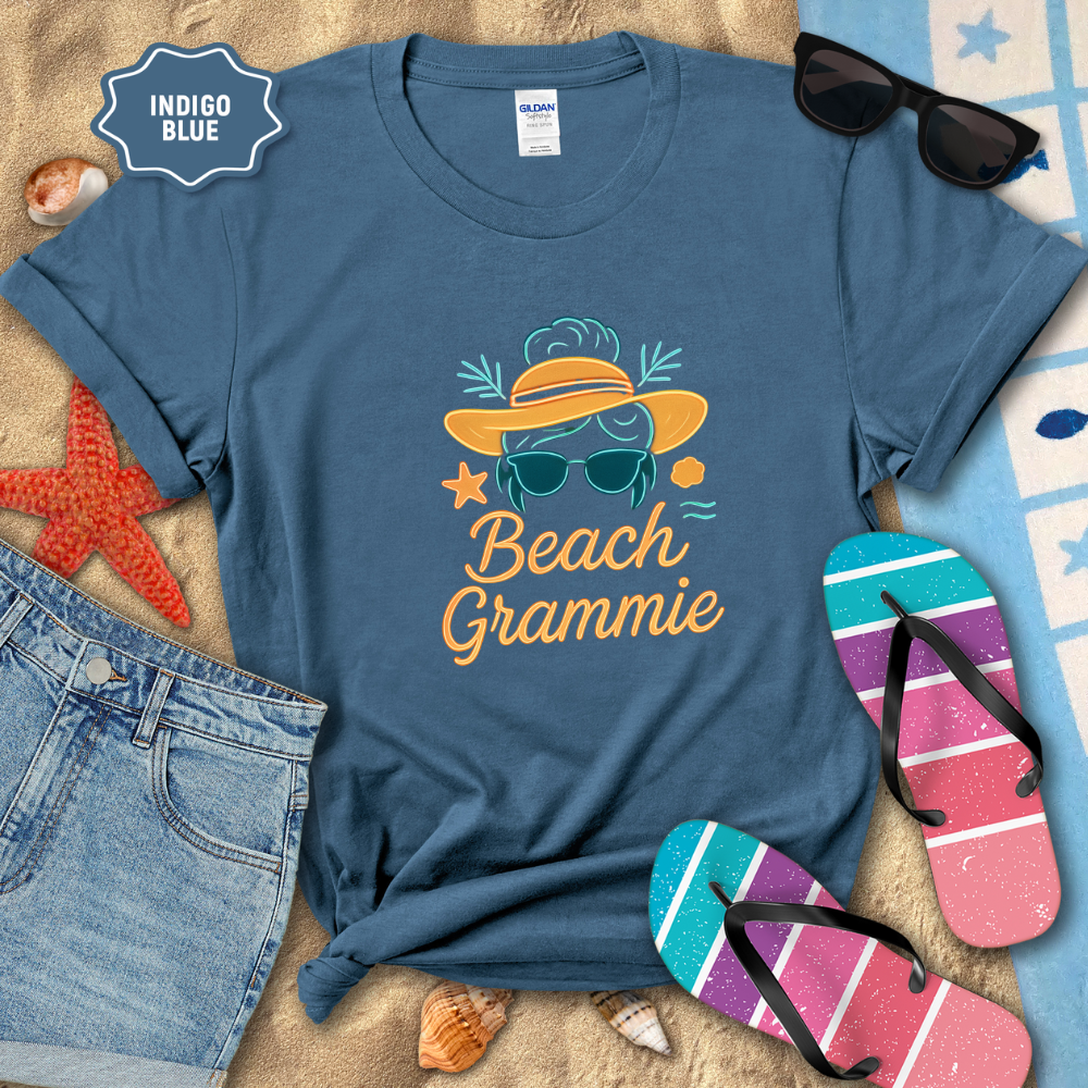 Indigo blue t-shirt with 'Beach Grammie' design on a sandy background with beach accessories.