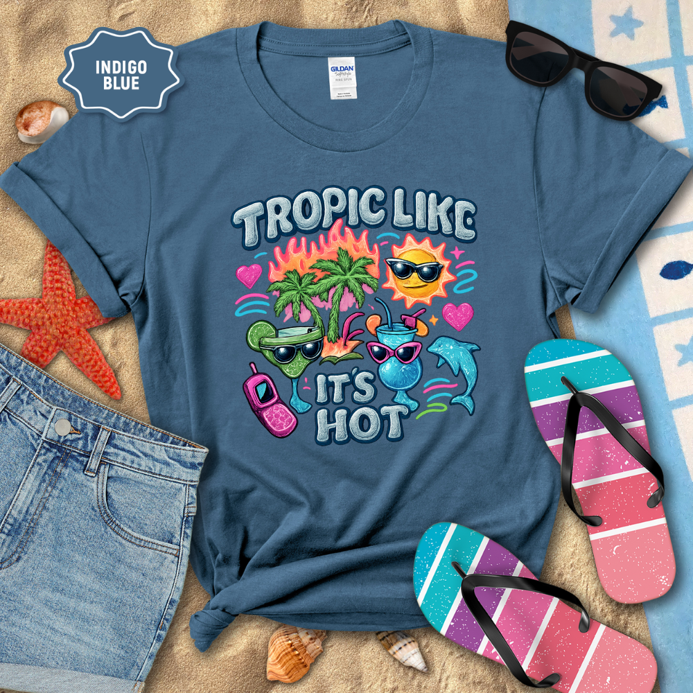 Indigo blue t-shirt with tropical design and beach accessories on a sandy background