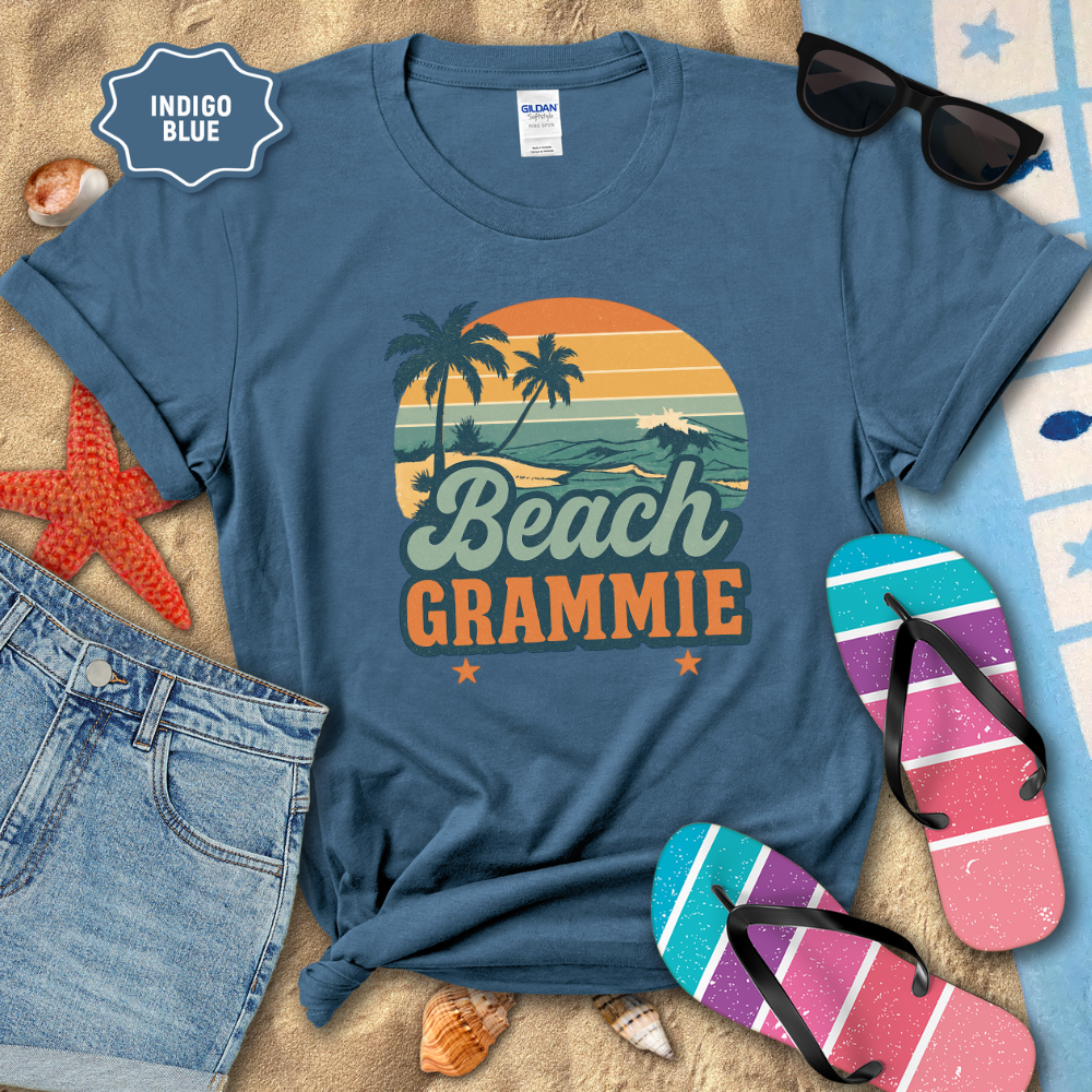 Indigo blue t-shirt with 'Beach Grammie' design on a sandy background with beach accessories.