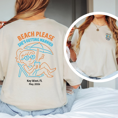 Beige t-shirt with 'Beach Please She's Getting Married' design on the back, worn by a person.