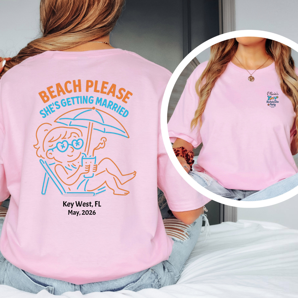 Pink t-shirt with beach-themed design and text, worn by a person.