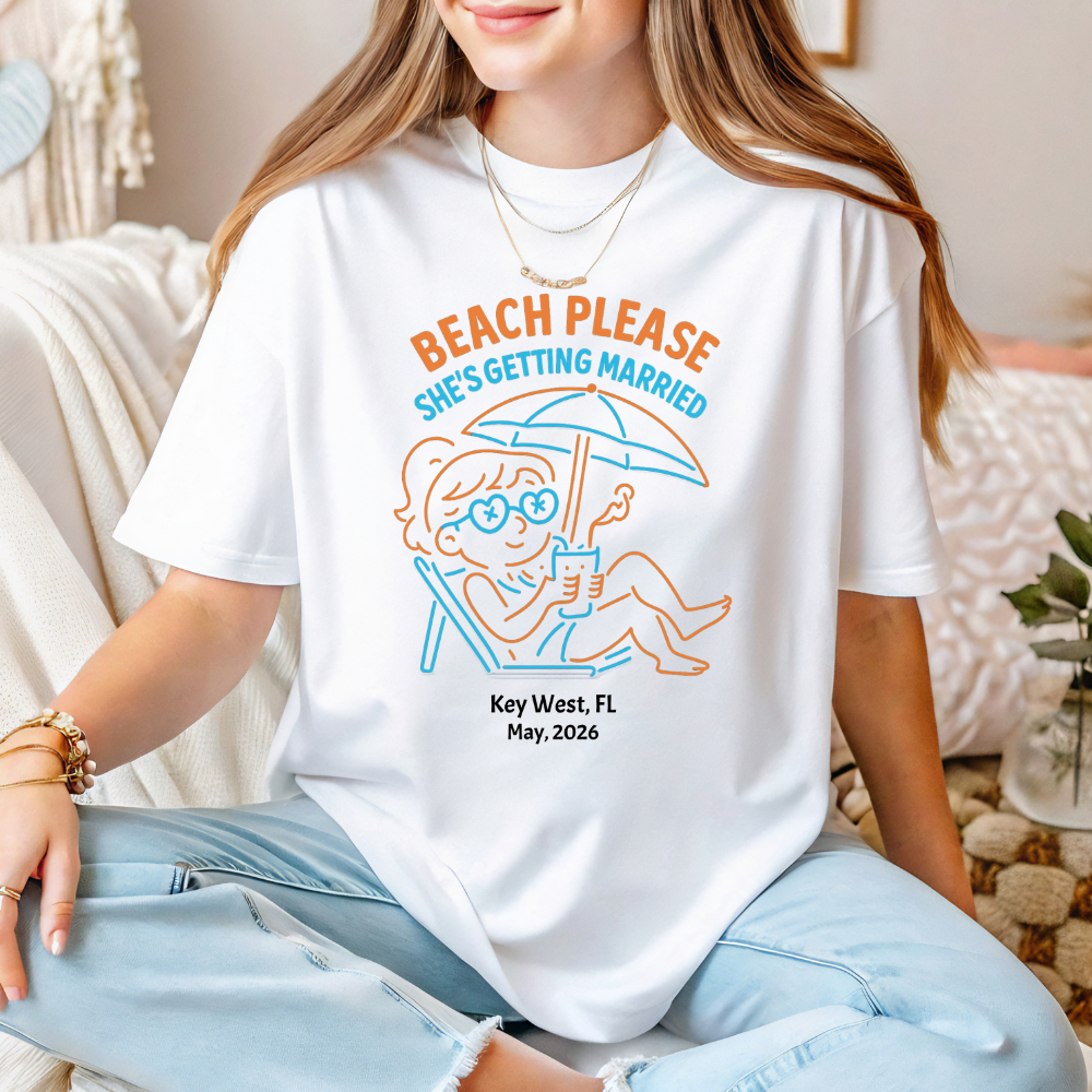 Person wearing a white t-shirt with a humorous graphic and text, sitting on a couch.