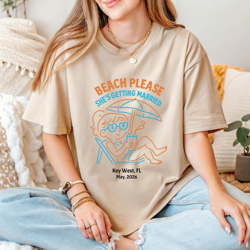 Person wearing a t-shirt with a beach-themed design and text.