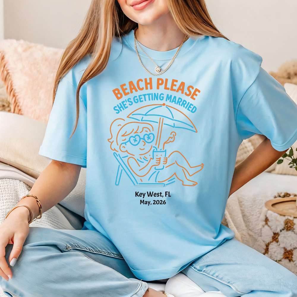 Person wearing a light blue t-shirt with a graphic and text, sitting on a couch.