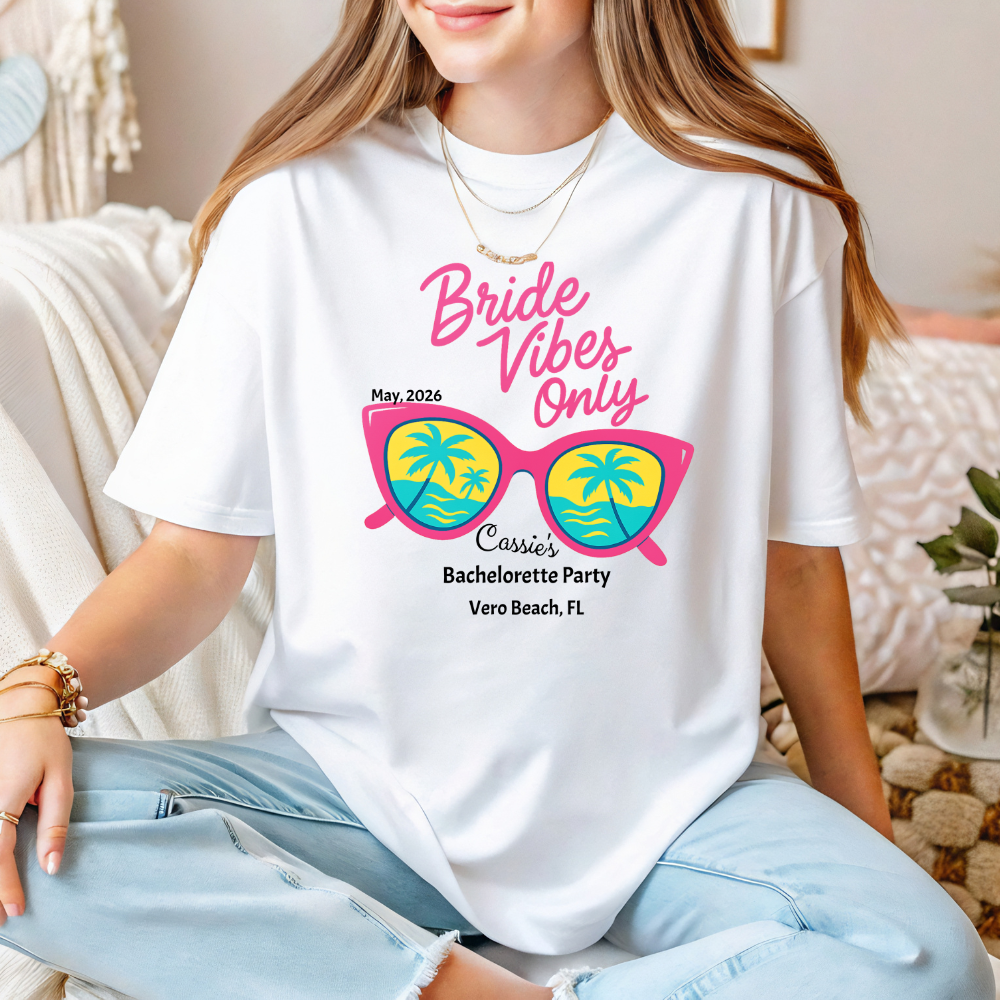 Person wearing a white t-shirt with 'Bride Vibes Only' design, sitting on a couch.