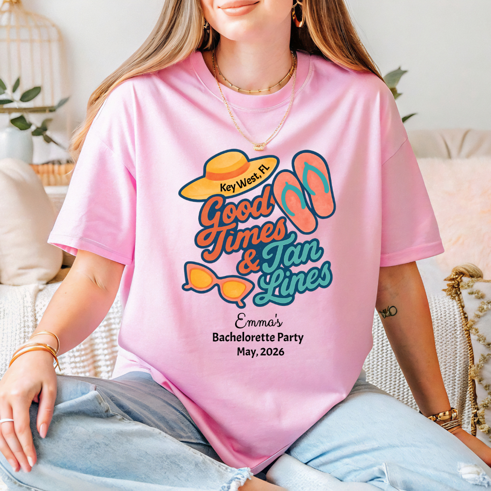 Person wearing a pink t-shirt with 'Good Times & Tan Lines' design and text.