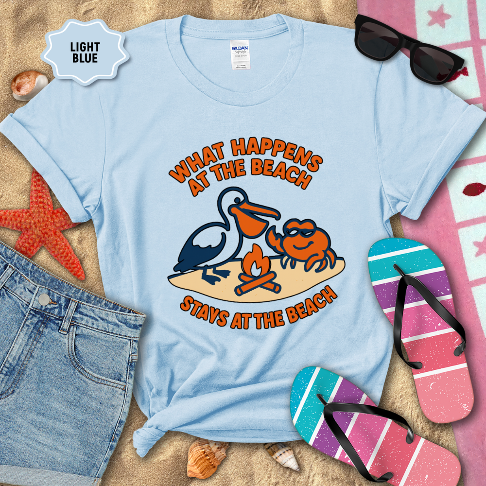 Light blue t-shirt with beach-themed design and accessories on sand